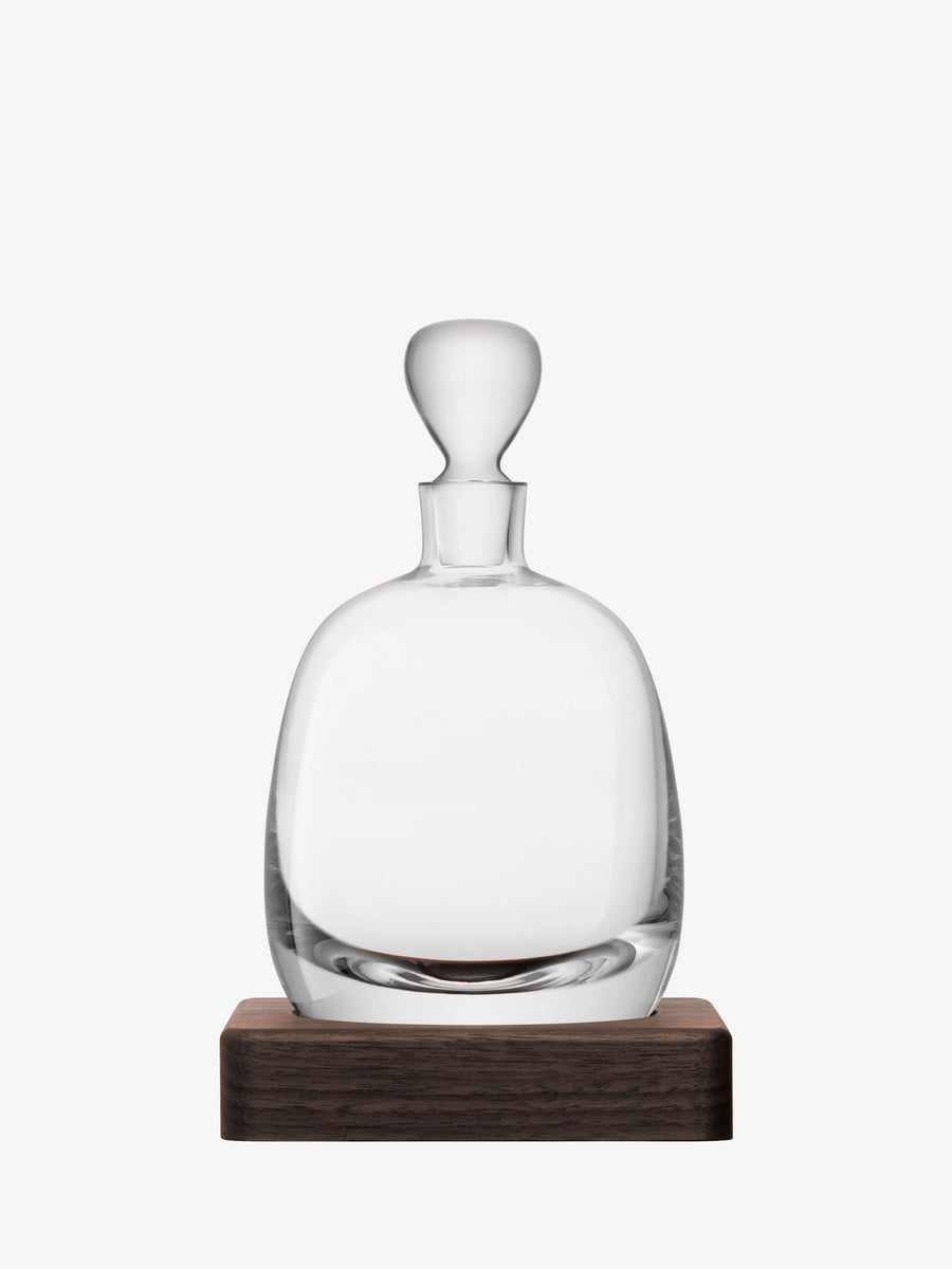 The Islay Decanter & Walnut Base by lsa-international, crafted from mouth-blown glass with a rounded stopper, is displayed on its rich walnut base against a plain white background.