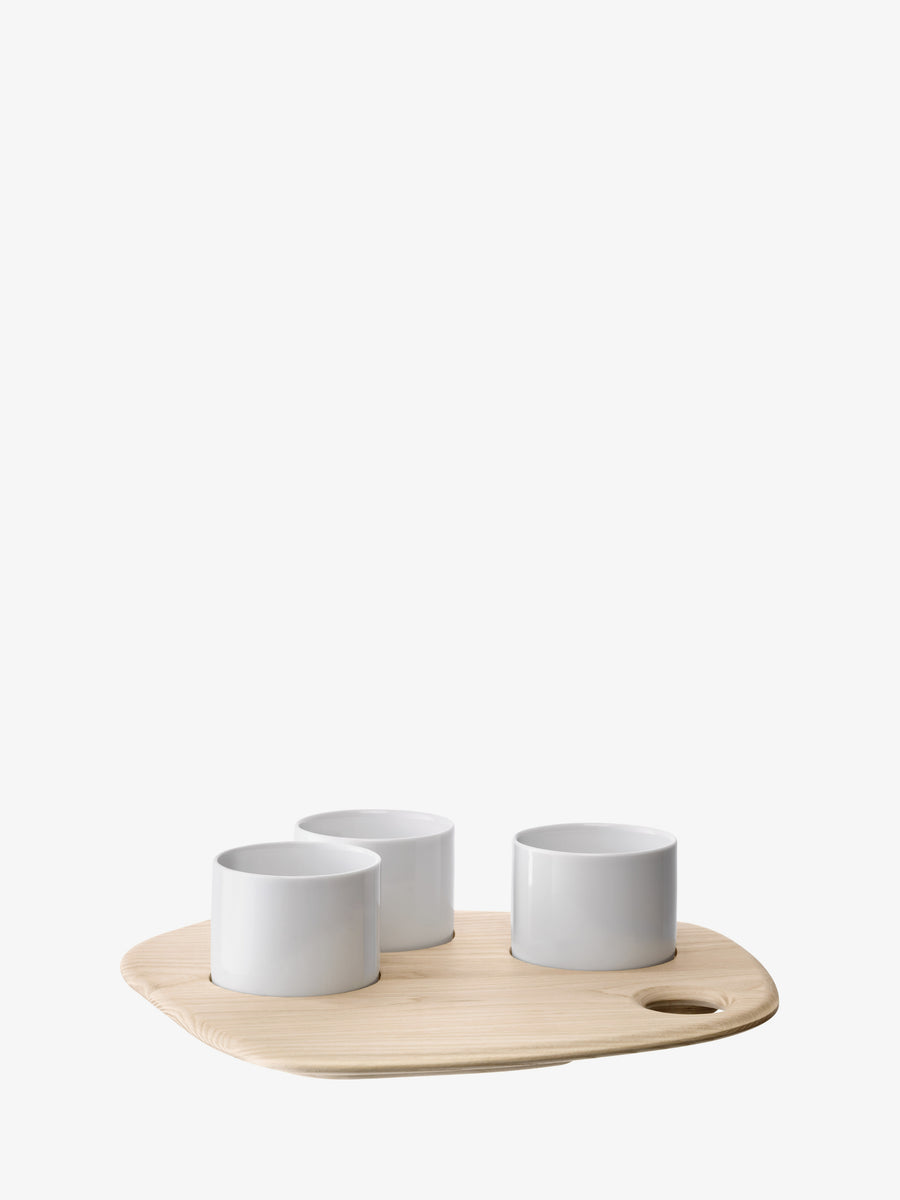 Three white porcelain bowls from lsa-international’s Tapas Set & Ash Board are arranged on a light ash serving board, which features a small round handle hole on the right side. The background is plain white.