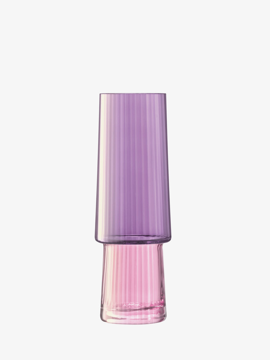 A stylish vase by lsa-international with a pleated texture and vertical grooves, featuring a striking dual-tone effect that transitions from purple at the top to pink at the bottom, set against a plain white background.