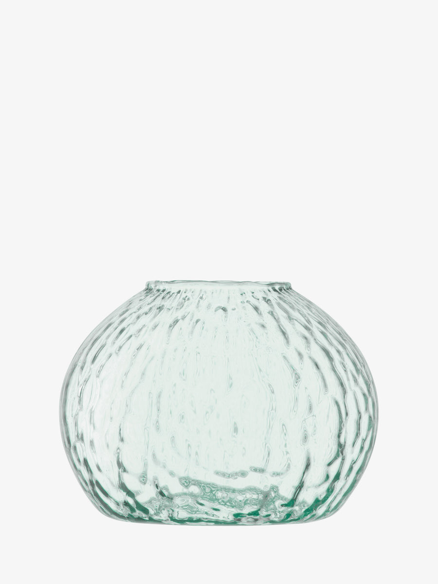 Introducing the Seed Vase by lsa-international—a clear, round wildflower vase crafted from recycled glass. It features a textured, dimpled surface, wide body, narrow flat base, and a small top opening. The transparent finish has a subtle greenish tint, displayed against a white background.