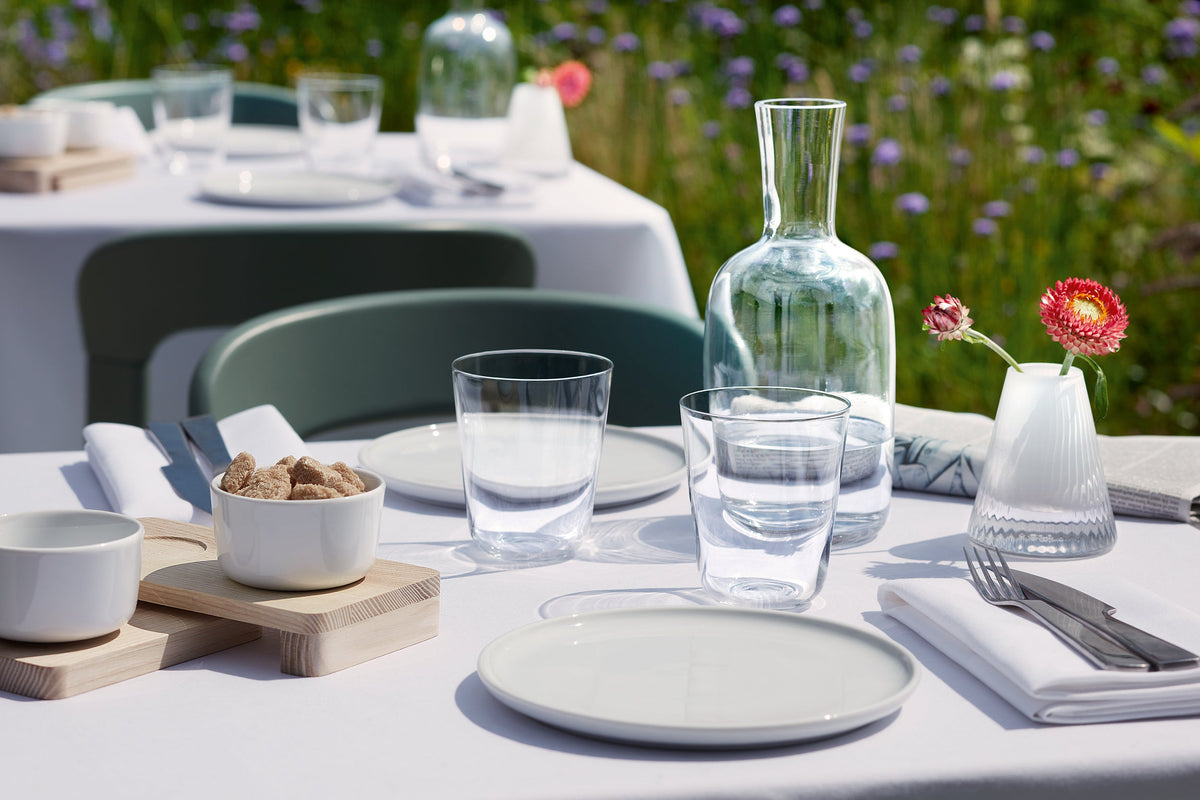 Outdoor lunch table setting with tumblers, carafe and lunch plate