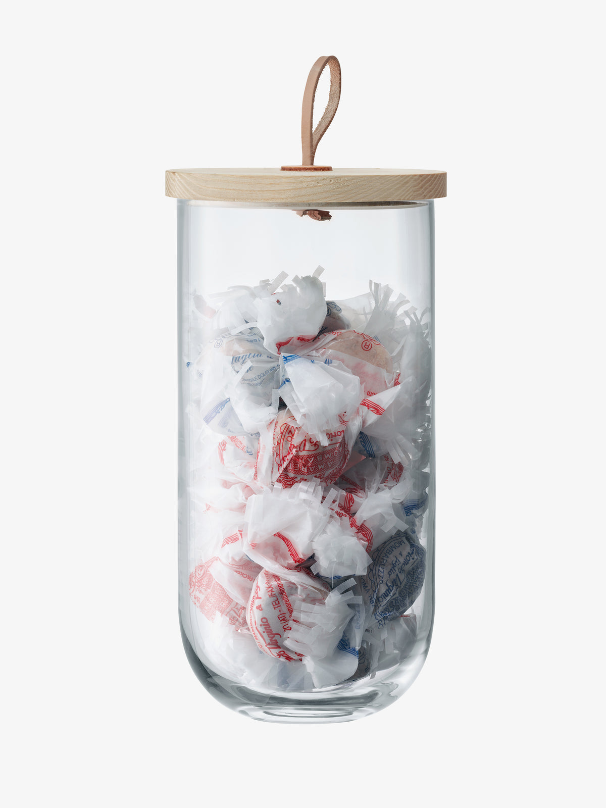 LSA International Container & Ash Lid: a mouth-blown glass storage jar filled with wrapped candies, topped with a sustainably-sourced ash lid and a leather loop handle.