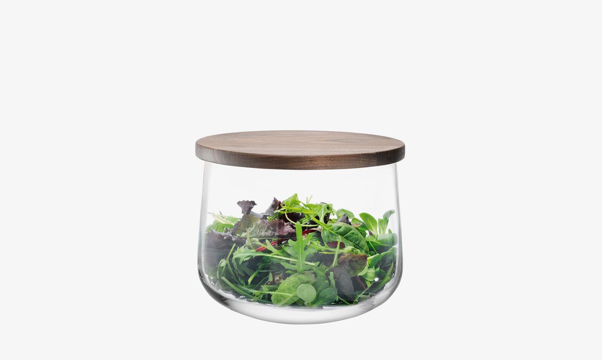 The lsa-international Bowl & Walnut Lid, a clear glass jar topped with a walnut lid and filled with mixed salad greens, is displayed against a plain white background.