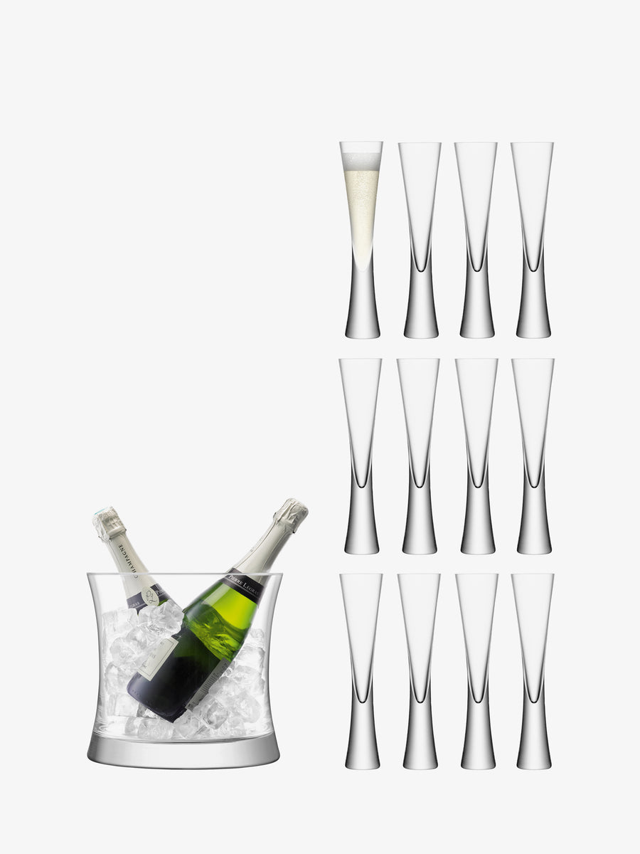 Two bottles of champagne rest in an elegant ice bucket on the left, while a group of ten empty mouth-blown glass champagne flutes from lsa-international’s Grand Serving Set and one filled flute are arranged vertically to the right on a white background—an inviting display perfect for showcasing the Grand Serving Set by lsa-international.