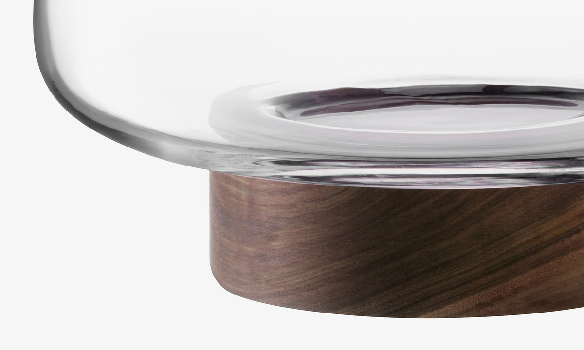 A close-up of the lsa-international Bowl & Walnut Base, featuring a clear glass bowl on a thick, round walnut base, displayed elegantly against a white background.