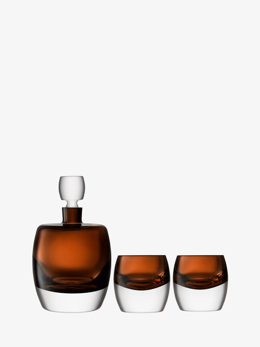 The lsa-international Whisky Set showcases a stylish combination of a brown glass and clear decanter paired with two matching short tumblers, all featuring rounded bases and displayed against a plain white background.
