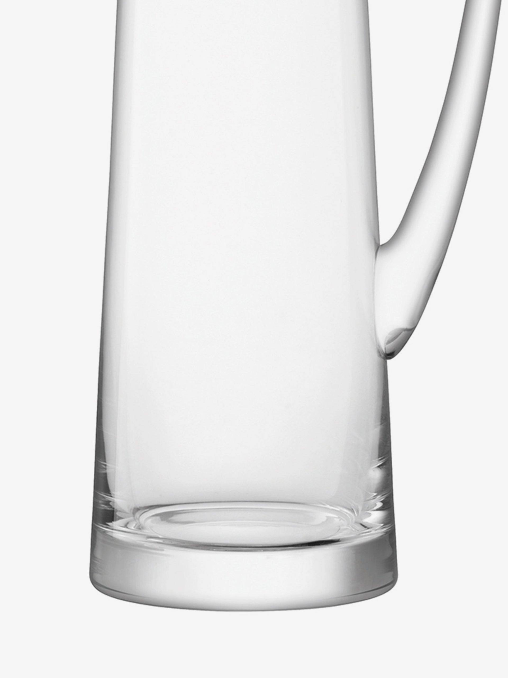 A clear glass pitcher with a large handle, shown against a white background. The pitcher is empty and has a modern, cylindrical design.
