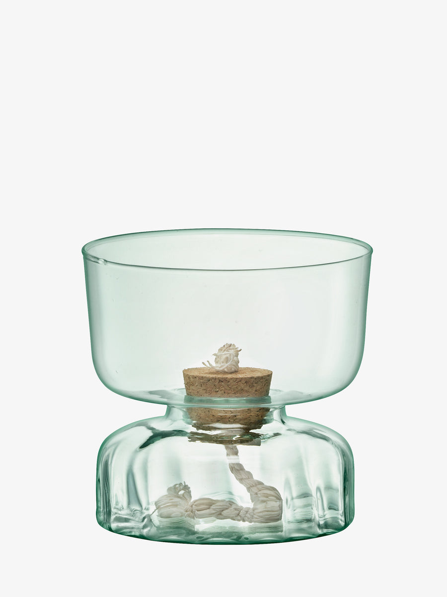 The Self Watering Planter Clear/Part Optic by lsa-international is a transparent planter crafted from recycled glass, featuring a wide bowl and narrow base. It includes a cork stopper and accommodates a small plant bulb with visible roots in water, offering a sustainable, self-watering design that beautifully showcases natural growth.