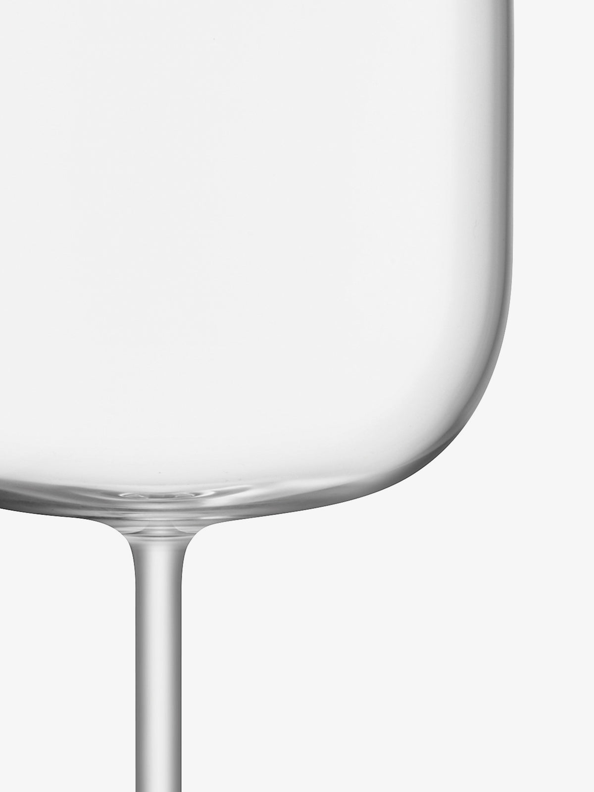 A close-up of the bottom and tall stem of an empty lsa-international Wine Glass, crafted from crystalline glass and set against a white background.
