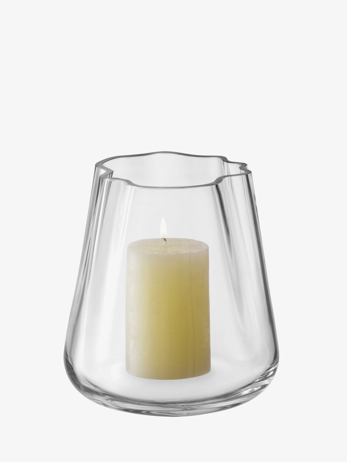 A lit cream-colored pillar candle sits inside an LSA International Vase/Lantern, crafted from mouth-blown glass with an organic, wavy rim.