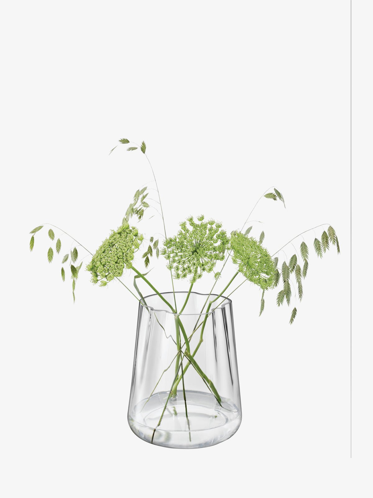 Clear, mouth-blown LSA-International Vase/Lantern holding green wildflowers and ornamental grasses.