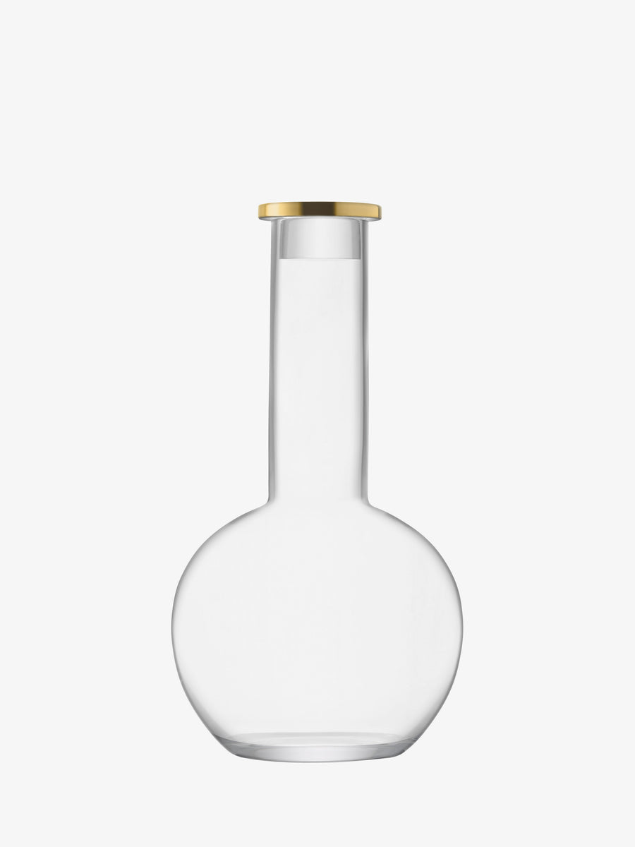 A clear, mouth-blown lsa-international Decanter & Stopper featuring a round base, tall narrow neck, and flat gold-colored lid is displayed against a plain white background.