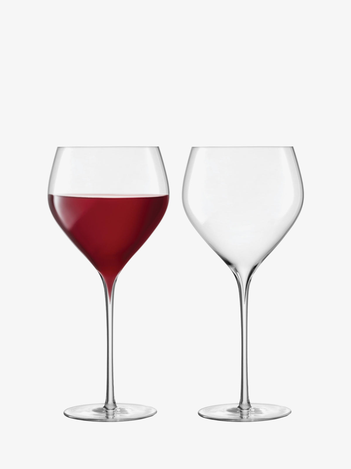 Set against a white background, two clear lsa-international Red Wine Glasses are displayed: the glass on the left, with its finely curved bowl, is half-filled with red wine, while the glass on the right—with its elegant, hand-drawn stem—remains empty.