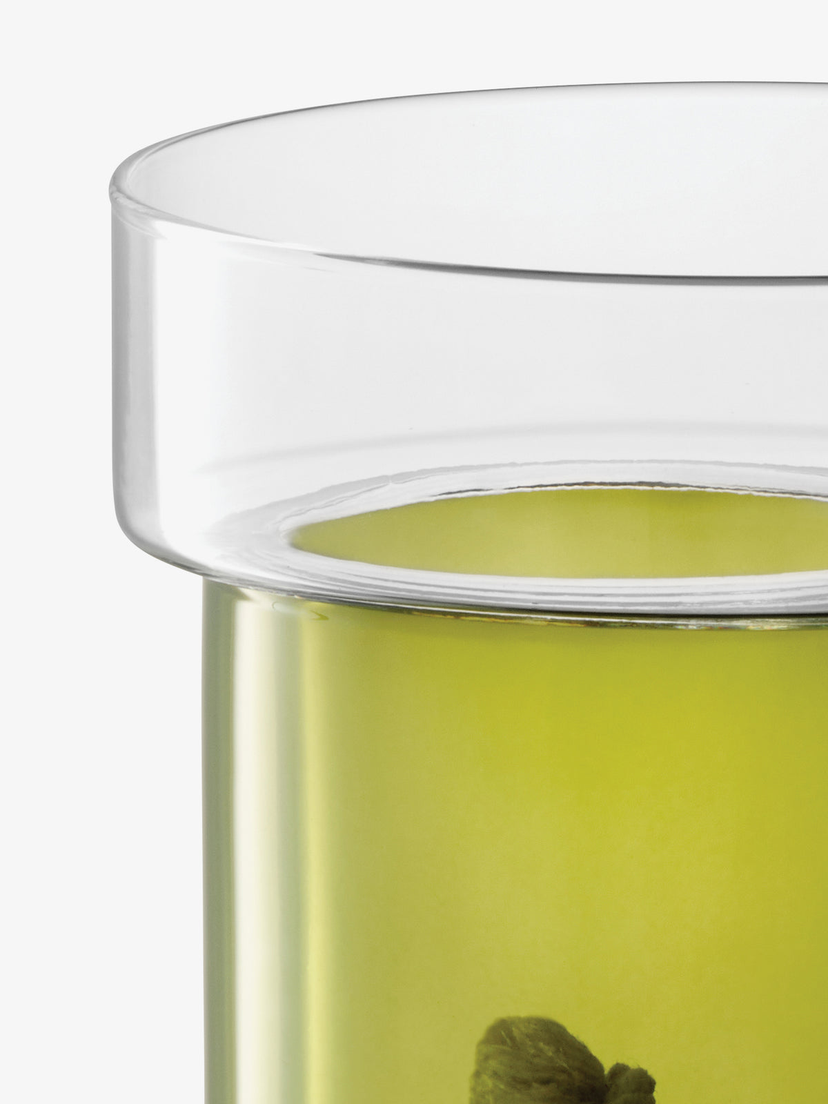 A close-up of a clear glass lsa-international Self Watering Planter containing a light green liquid and a small plant, featuring a wide rim and an integrated sub-irrigation system.