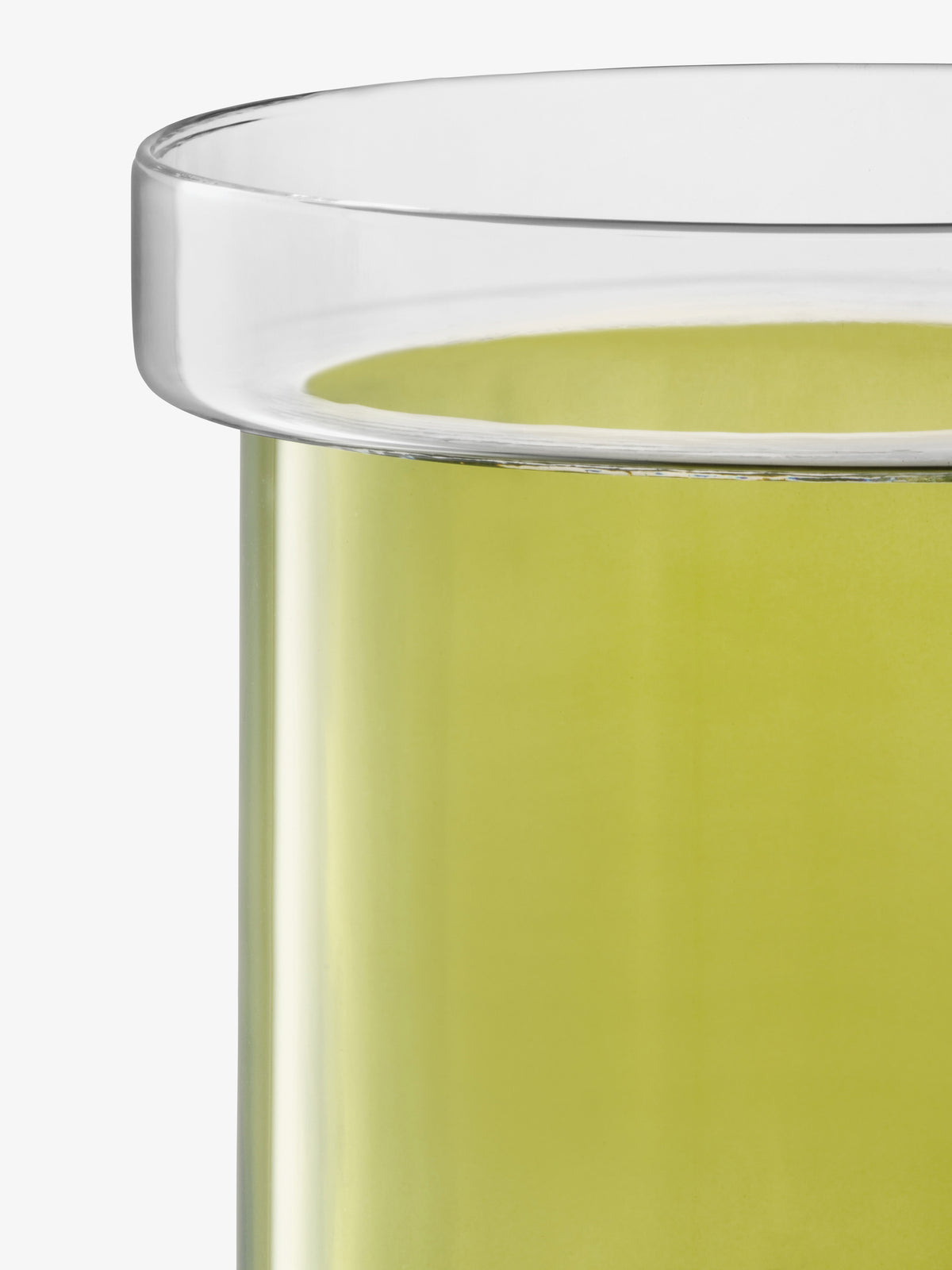 Close-up of a clear glass cylinder with a wide rim containing light green liquid, serving as an LSA International Self Watering Planter.