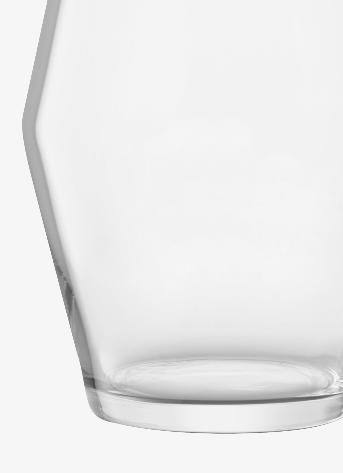 Close-up of a modern LSA International vase, mouth-blown with a wide, rounded base and faceted sides.