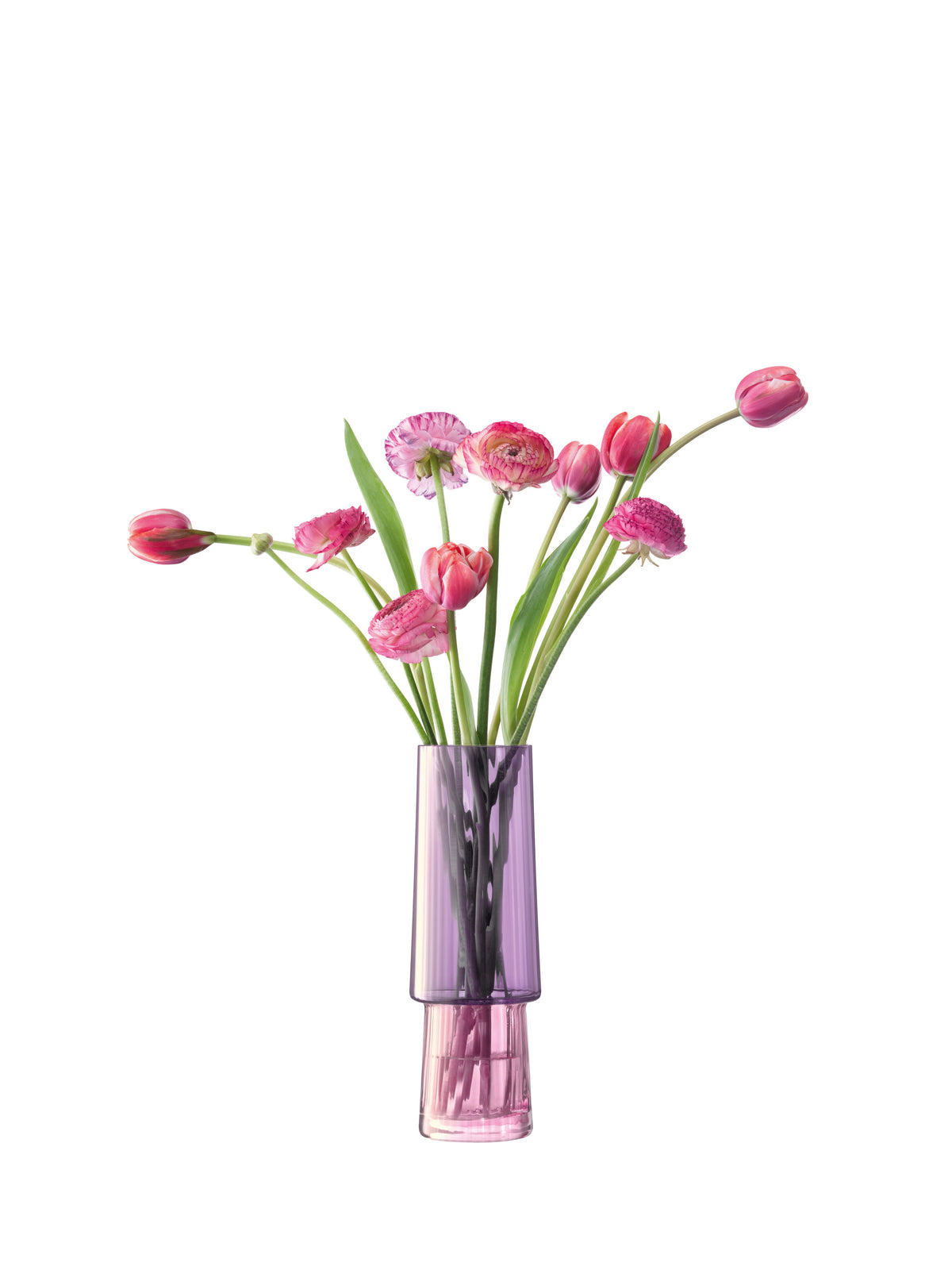 A bouquet of pink tulips and ranunculus flowers arranged in an lsa-international Vase—tall, mouth-blown, and crafted from translucent purple iridescent glass—set against a white background.