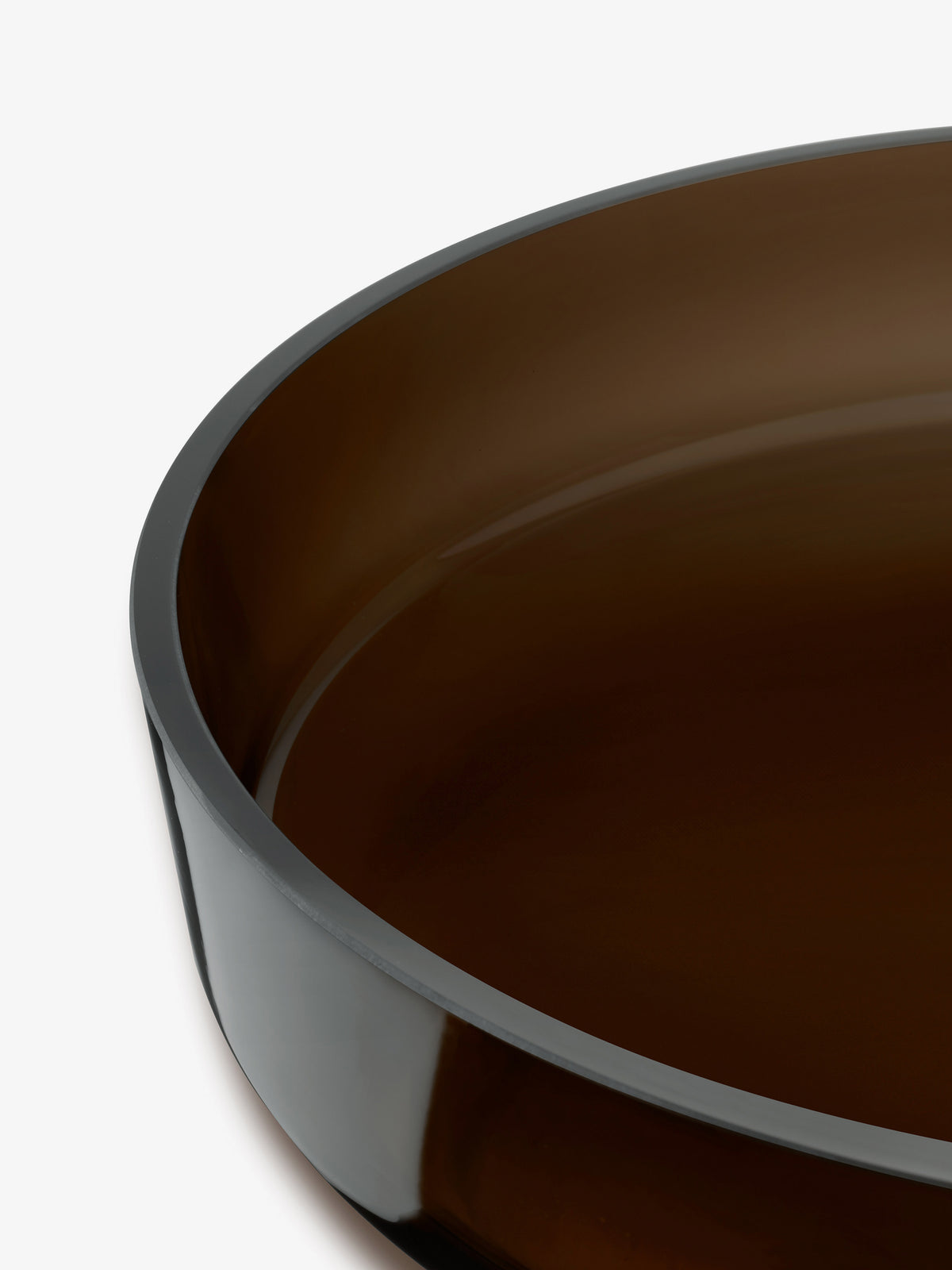 Close-up of a contemporary Low Glass Bowl in dark brown, featuring a wide, shallow rim.