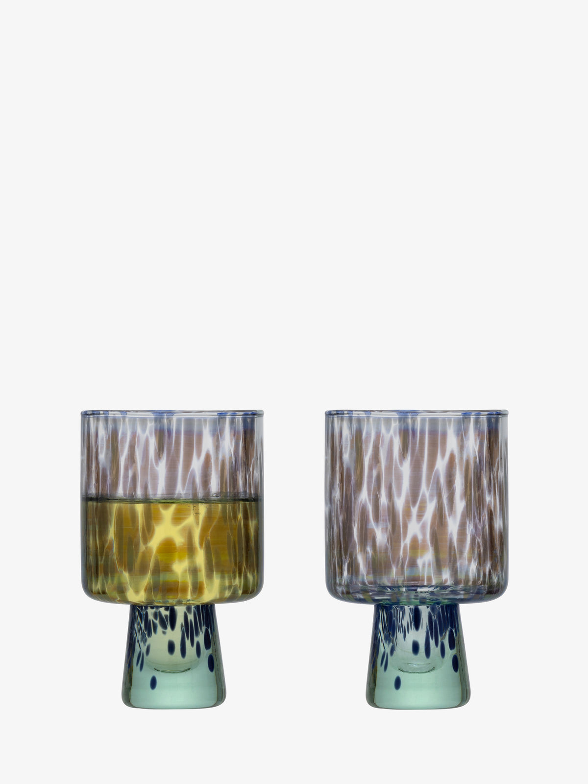 Two transparent, patterned lsa-international Wine Glasses with wide bowls and short, thick bases are shown side by side. Crafted from recycled glass, these tonal glasses feature subtle blue dot details on their bases. The left Wine Glass contains a yellow liquid, while the right one is empty.