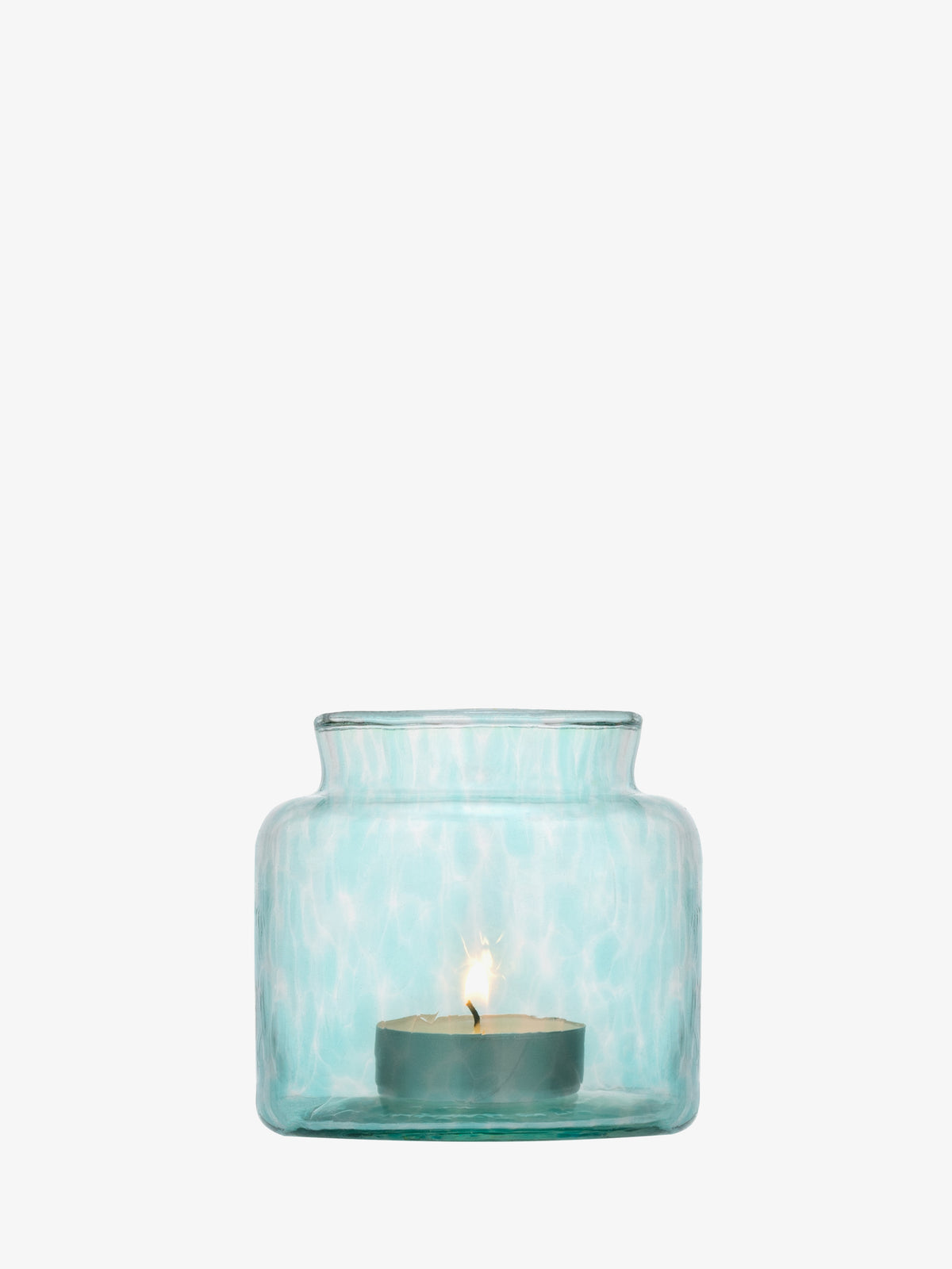 A small tealight candle burns inside the lsa-international Tealight Holder/Vase, crafted from transparent light blue recycled glass with a wide body and narrow neck, set against a plain white background.