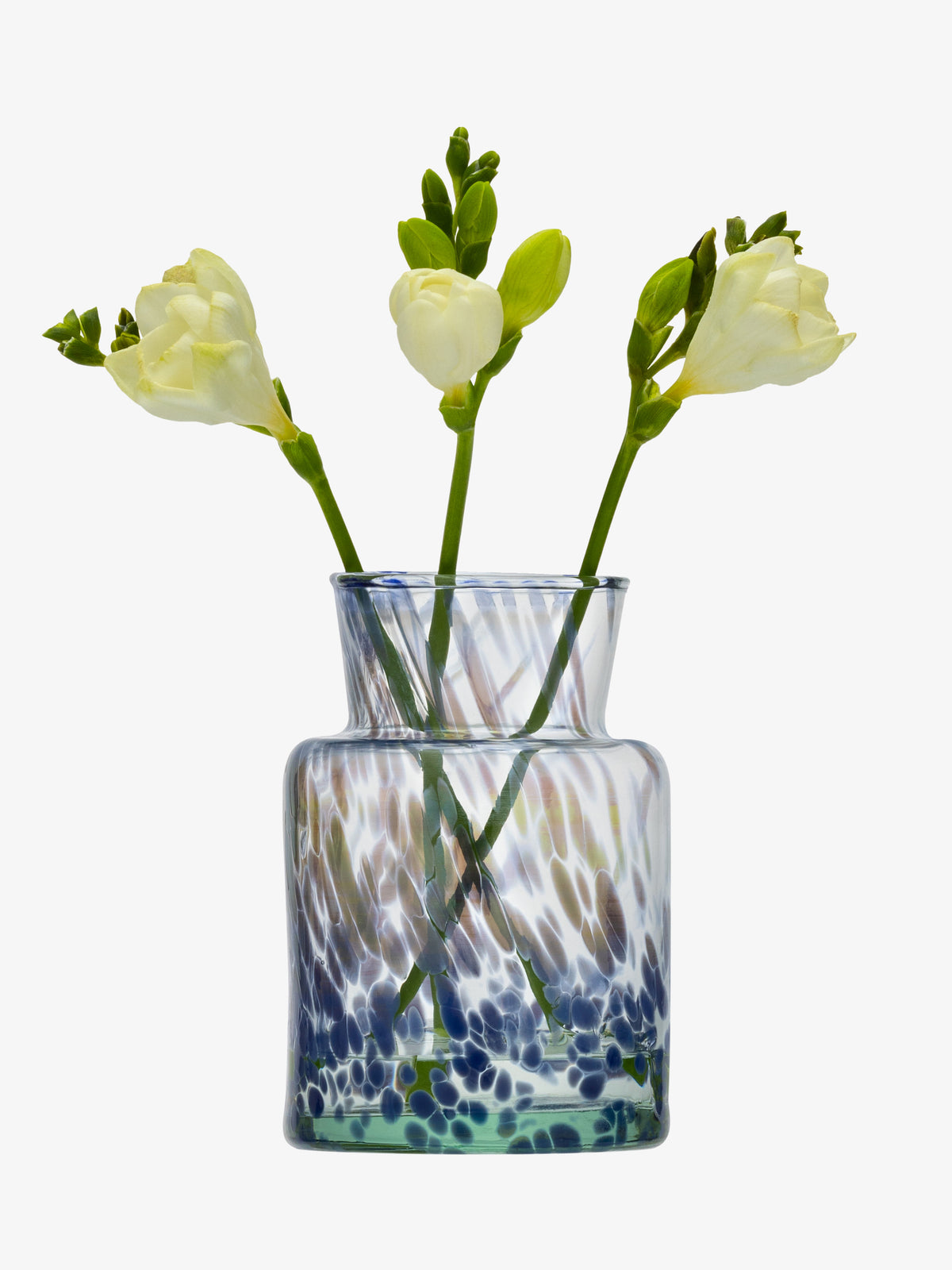 Three yellow and white flowers with green stems arranged in the lsa-international Bud Vase—a clear, mouth-blown glass vessel adorned with blue, green, and brown speckled patterns—set against a white background.