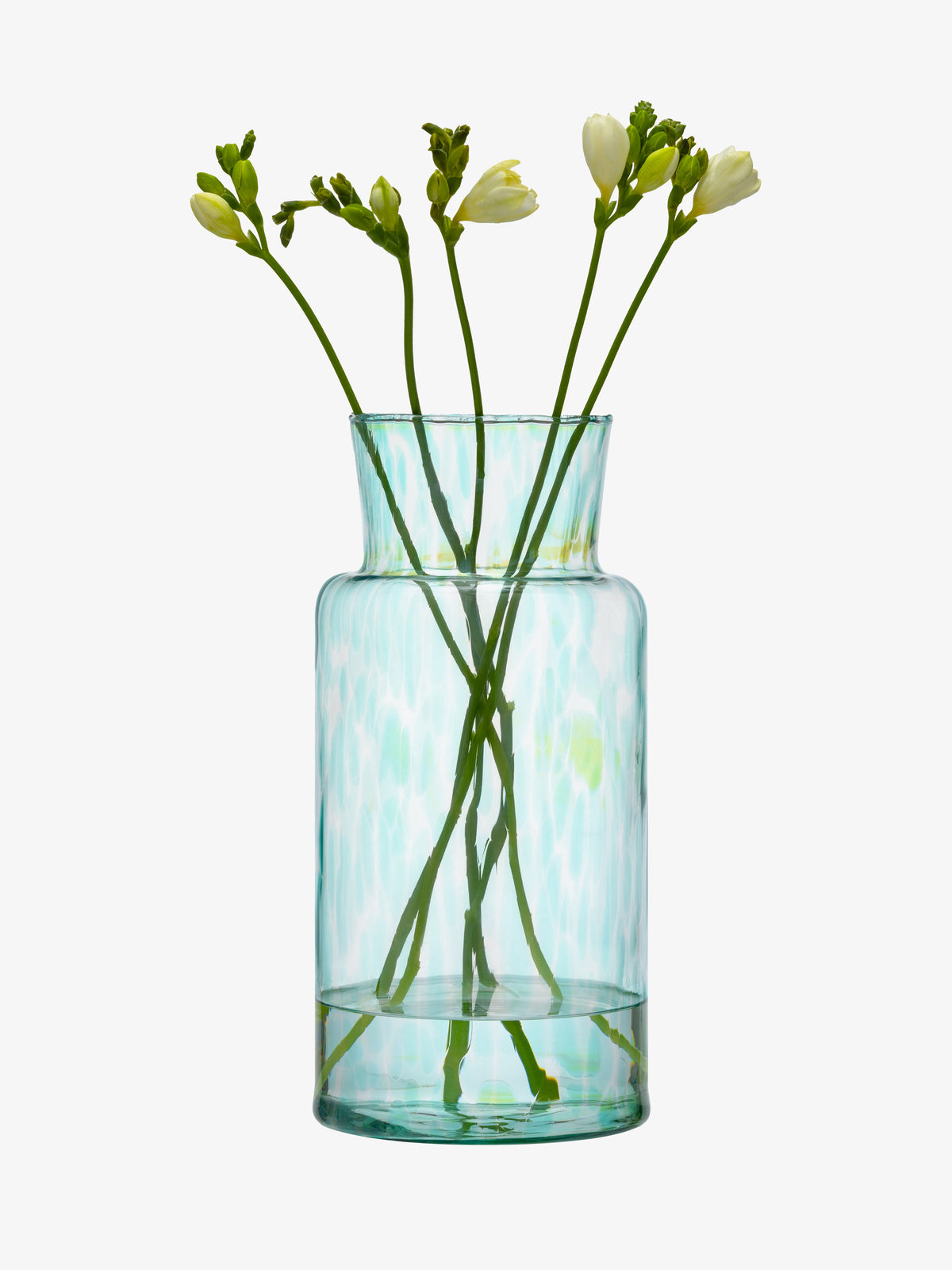 A lsa-international Vase made from clear, textured recycled glass in light blue-green hues—reminiscent of sea glass—holds several long-stemmed white flowers with small buds, set against a plain white background.