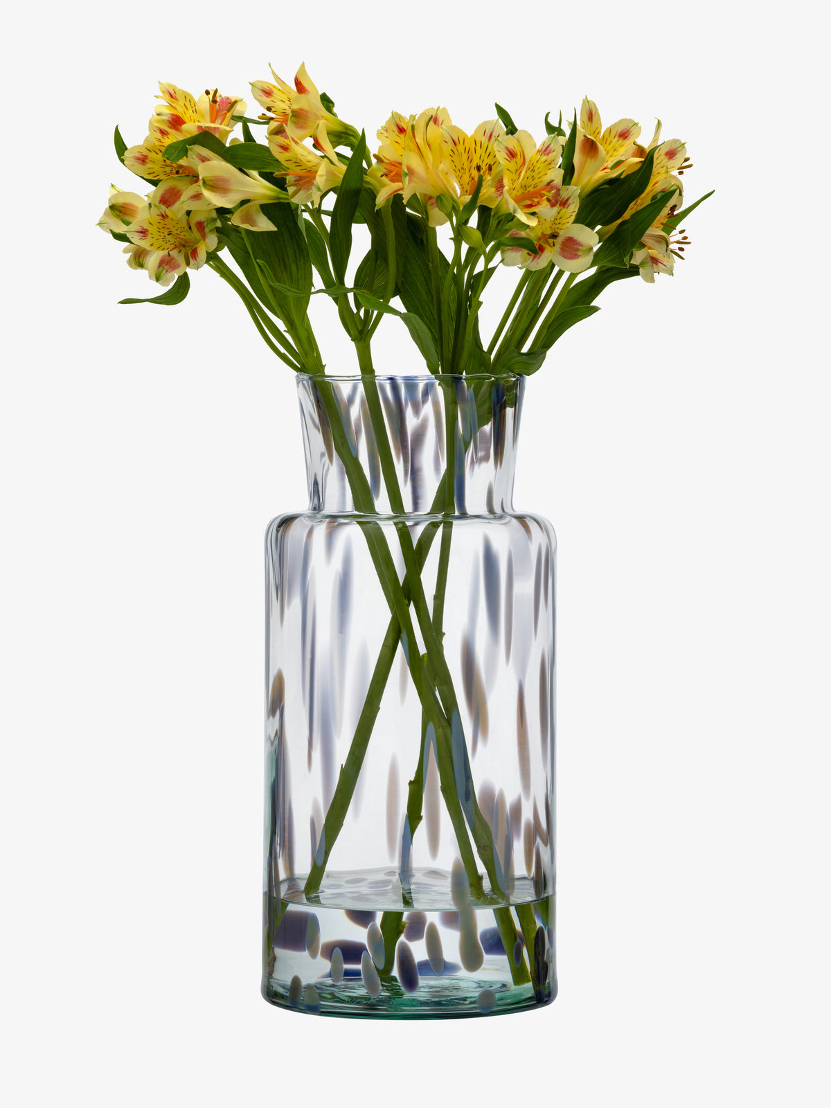 A clear recycled glass Vase by lsa-international holds yellow and orange flowers with green stems, set against a white background.