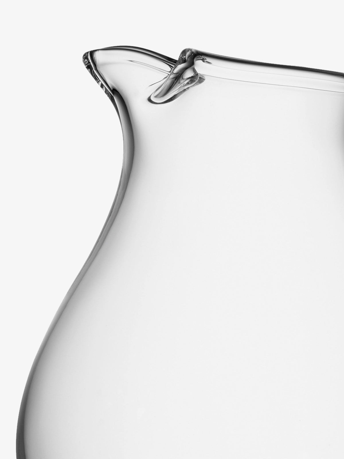 A close-up of the lsa-international Icelip Jug, mouth blown from clear glass, set against a white background. The image highlights the hand-formed icelip at the spout and the elegantly curved side of this unique pitcher.