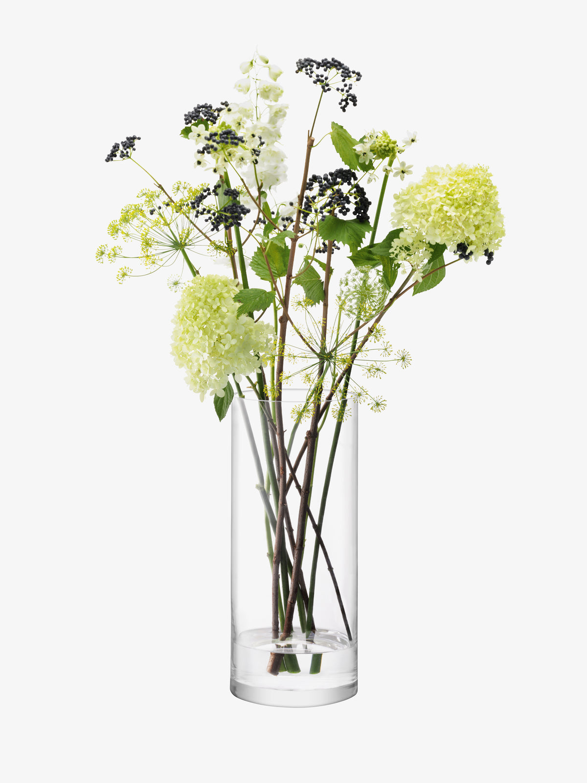 LSA International vase, hand-finished and cylindrical in clear glass, filled with green hydrangea blooms, white flowers, and stems of small dark berries.