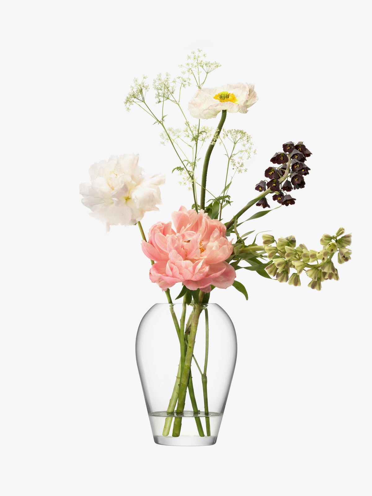 The Garden Bouquet Vase by lsa-international, crafted from mouth-blown glass, showcases an assortment of flowers—featuring a pink peony, a white poppy, dark purple blooms, and delicate green foliage—arranged against a plain white background.