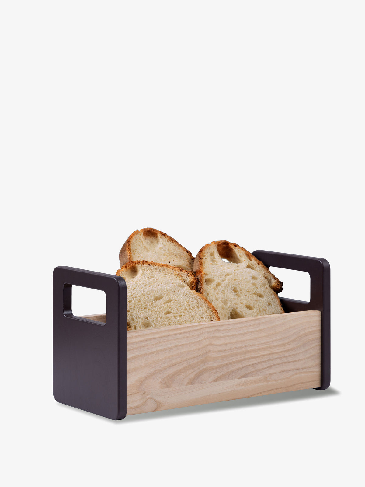Minimalist lsa-international Ash Bread Basket in European ash with dark handles, containing four slices of crusty bread.