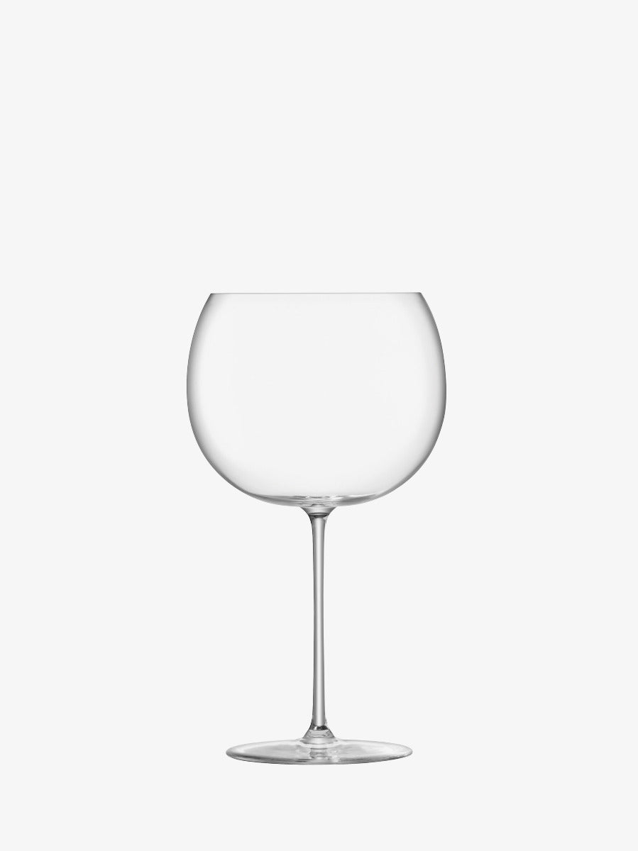 A clear, empty wine glass with a round bowl and long stem, set against a plain white background.