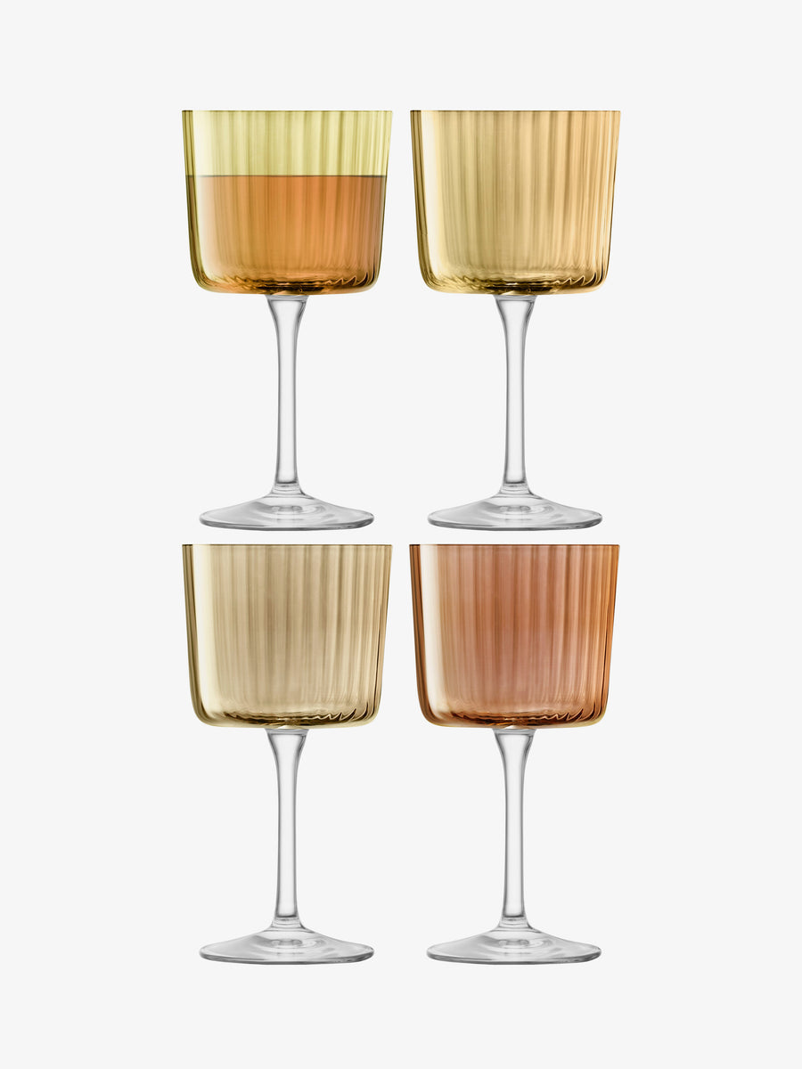 A set of four lsa-international Wine Glasses with ribbed, textured surfaces, each showcasing a unique shade of amber or gold, are displayed in a two-by-two grid on a white background.