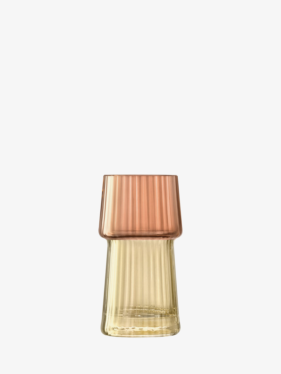 A ribbed glass vase by lsa-international, featuring a pleated texture and an amber-colored base that fades to a rose gold top, showcasing a striking dual-tone effect, set against a plain white background.