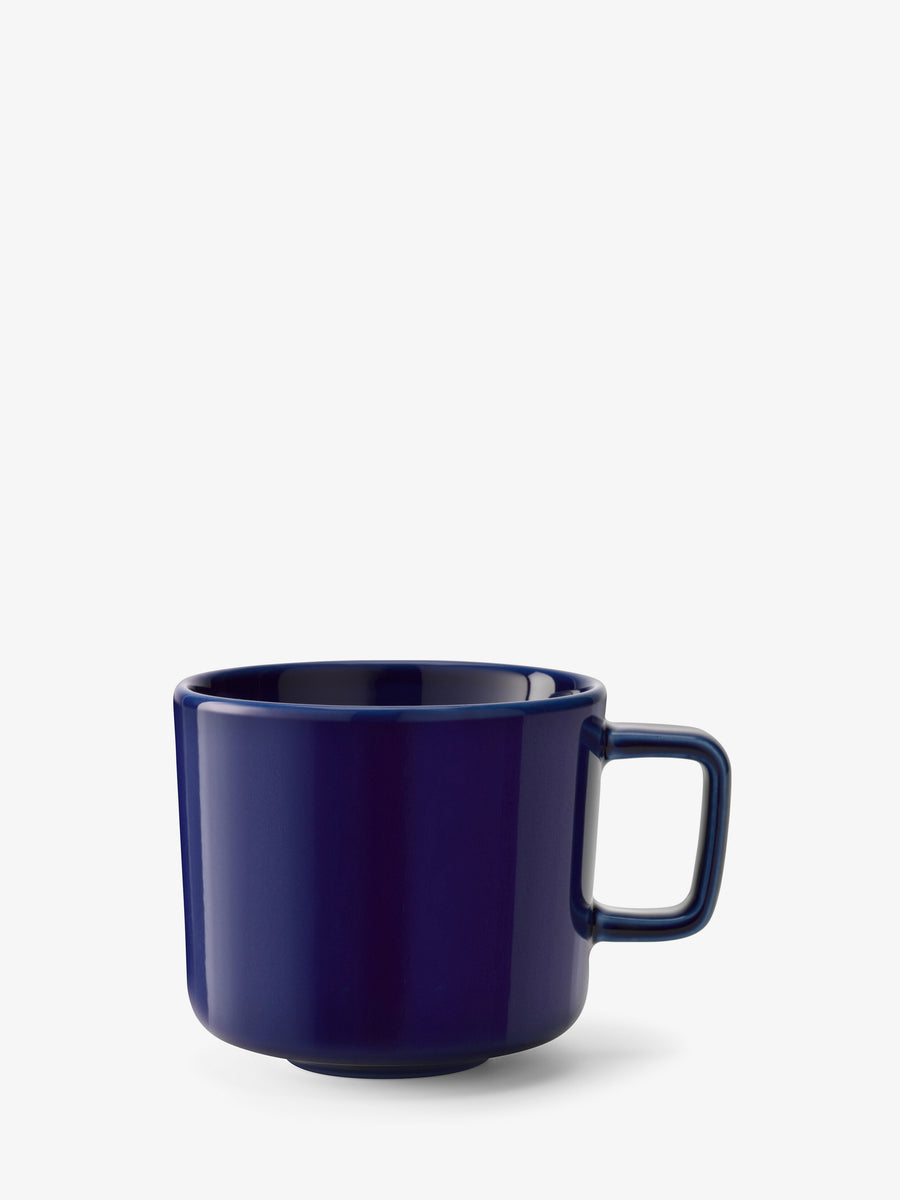 A contemporary “lsa-international” Coffee/Tea Cup, featuring a dark blue ceramic body and a square handle, is displayed on a plain white background.