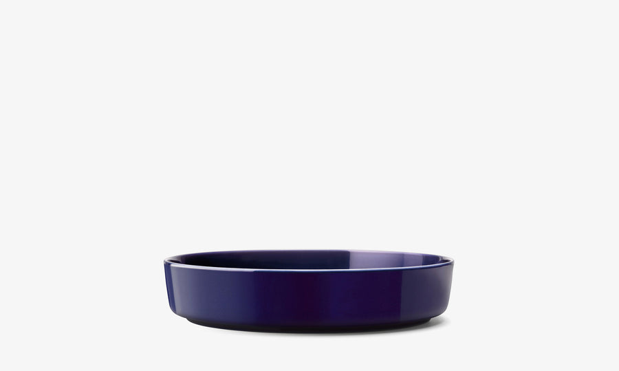 A deep, round, dark blue porcelain Serving Bowl by lsa-international is centered against a plain white background, showcasing the elegance of contemporary tableware.