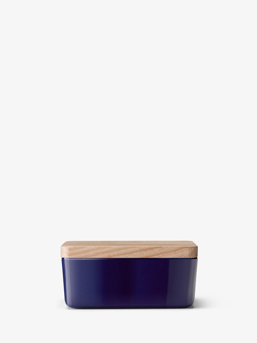 The lsa-international Butter Dish & Ash Lid features a rectangular dark blue porcelain base paired with a light ash wood lid, showcased against a white background—a contemporary serving piece that brings modern style to your table.